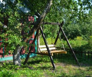 wooden garden swing seat under tree, original photo by lex20 from getty images
